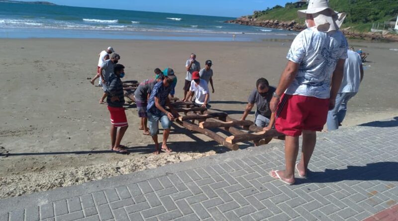 Pescadores do Farol preparando a rampa para a descida do barco na Prainha, onde o surfe está proibido durante a temporada da tainha.